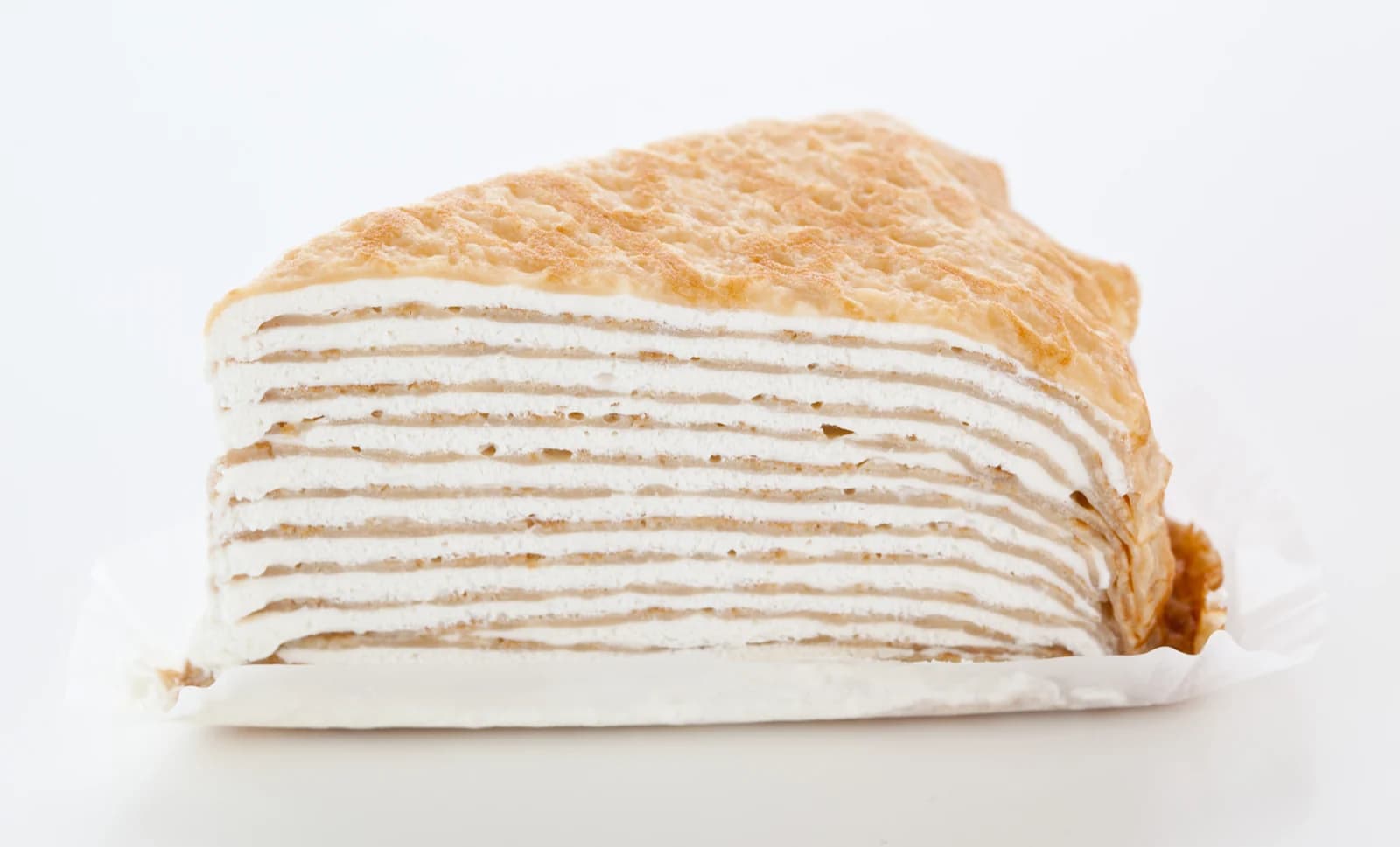 A slice of mille-crepe cake showing many thin crepe and cream layers