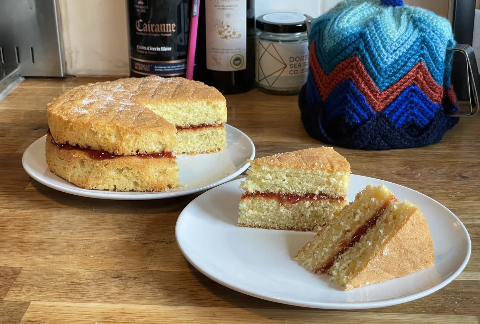 A Victoria sponge cake with slices removed to show the crumb and filling