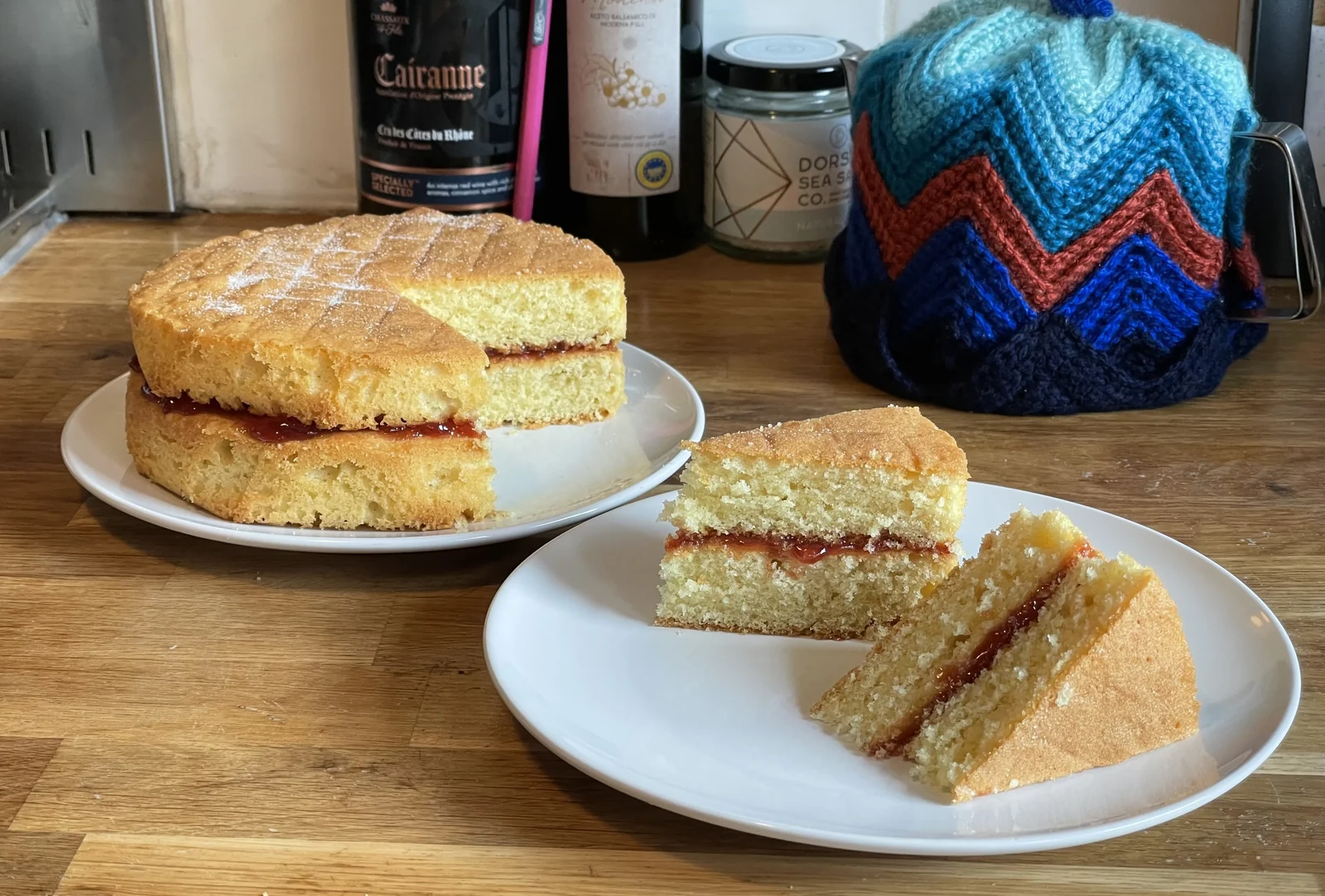 A Victoria sponge cake with slices removed to show the crumb and filling