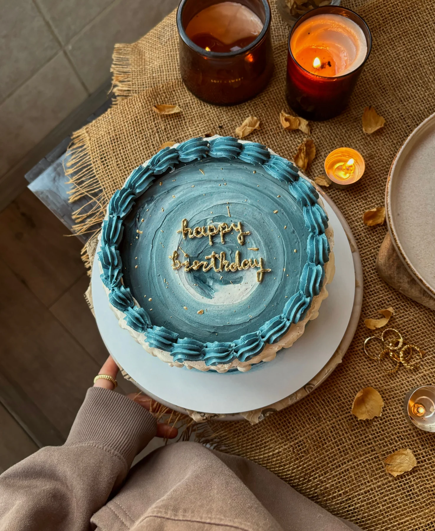 A blue cake with piped shell borders and a gold birthday message